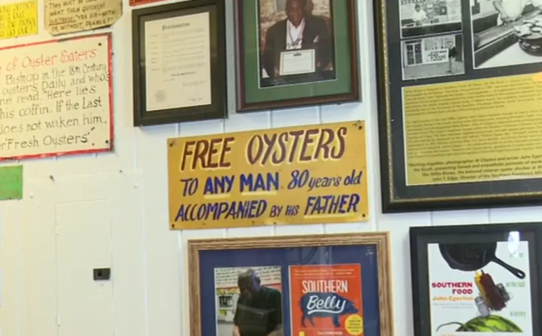 Picture of a sign saying "Free oysters to any man 80 years old accompanied by his father” hanging on a restaurant wall