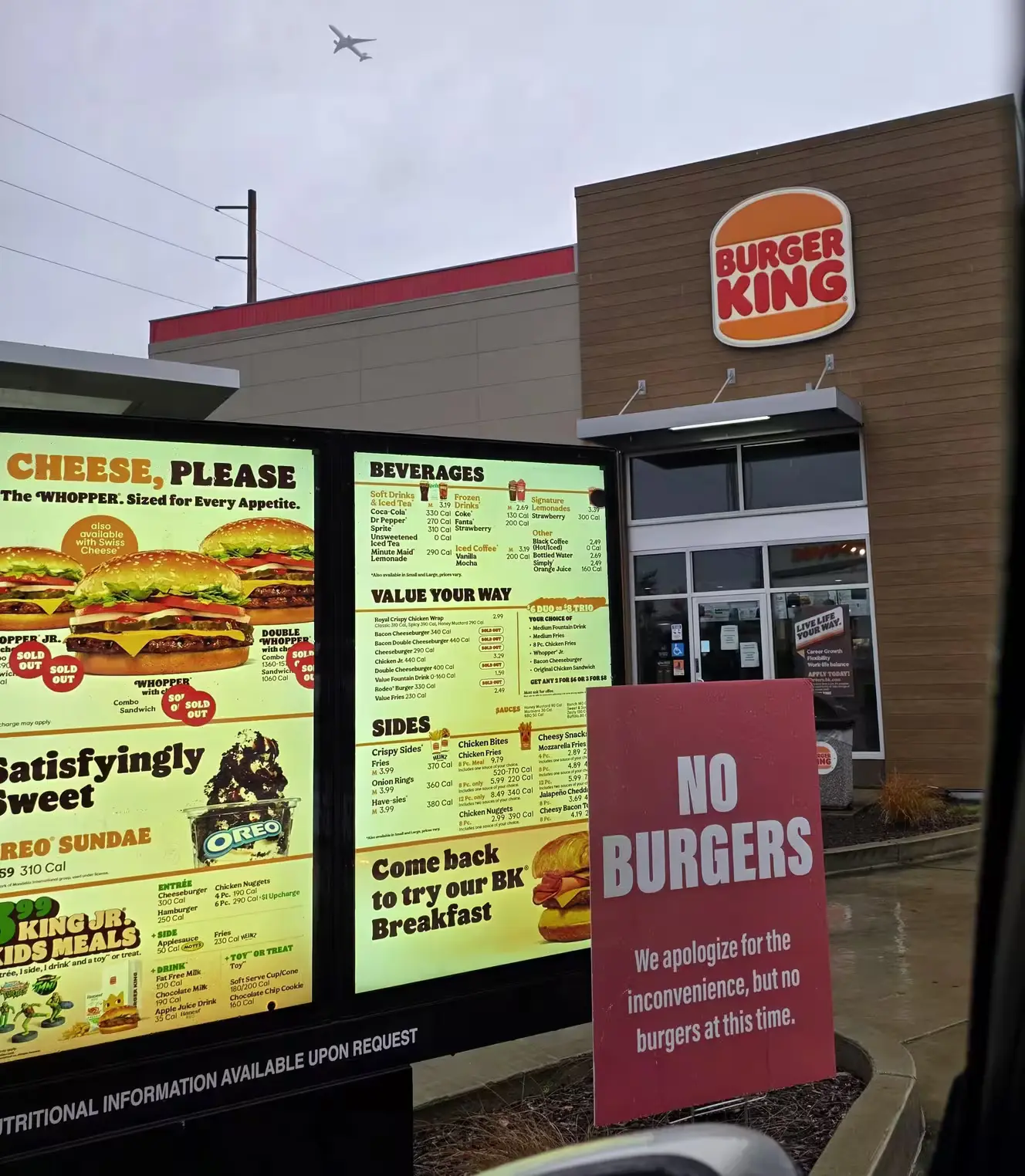 a picture of a burger king drive through - there is a sign posted that states they have no burgers a picture of a burger king drive through - there is a sign posted that states they have no burgers